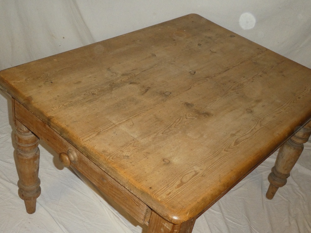 An old polished pine rectangular kitchen/dining table with a drawer in one end on turned tapered - Image 2 of 2