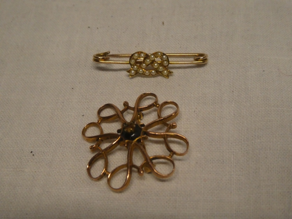 A 9ct gold interlaced brooch (minus stone) and an unmarked gold bar brooch set seed pearls (2)