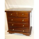 A small polished mahogany table chest of two short and three long drawers with brass handles on