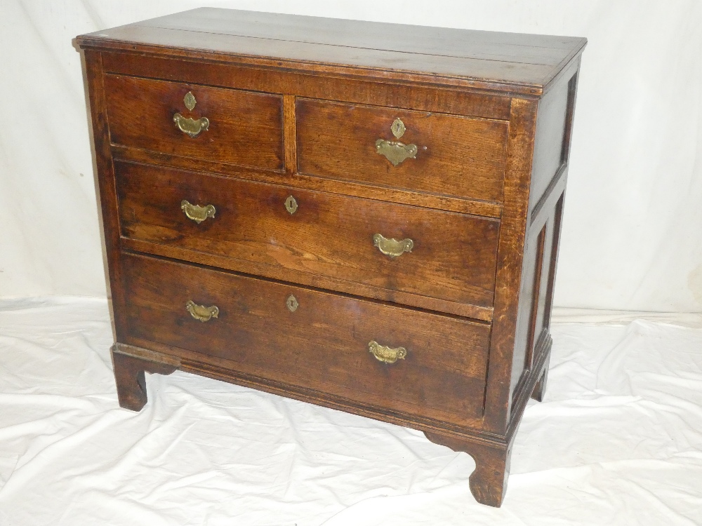 An 18th century oak chest of two short and two long drawers with brass ring handles on bracket feet