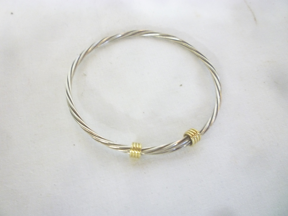 An 18ct gold mounted silver sprung bangle by Tiffany and Co