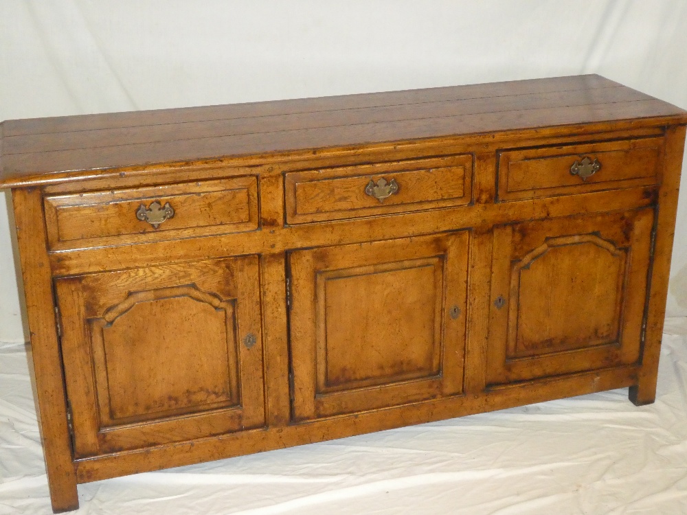 A good quality Georgian-style oak dresser base with three drawers in the frieze and cupboard