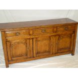 A good quality Georgian-style oak dresser base with three drawers in the frieze and cupboard