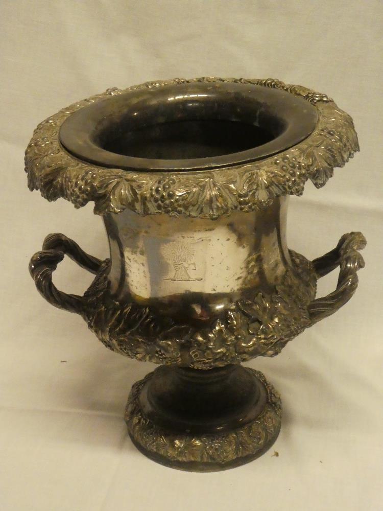 An old silver-plated circular two handled wine cooler with raised grape and leaf decoration and