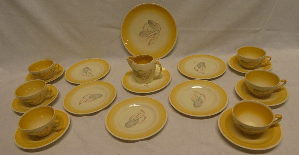 A Susie Cooper china tea set with painted leaf decoration within yellow borders comprising six tea