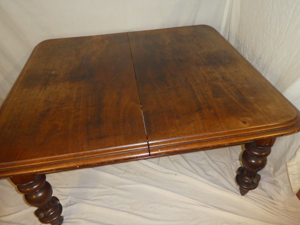 A Victorian mahogany rectangular extending dining table on bulbous turned tapered legs with brass