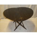 An unusual stained beech coaching-style circular folding table by Thornton & Hearne of London on