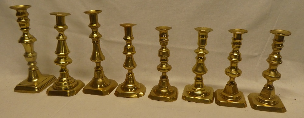 A pair of 19th century brass baluster-shaped ejector candlesticks and six other various brass