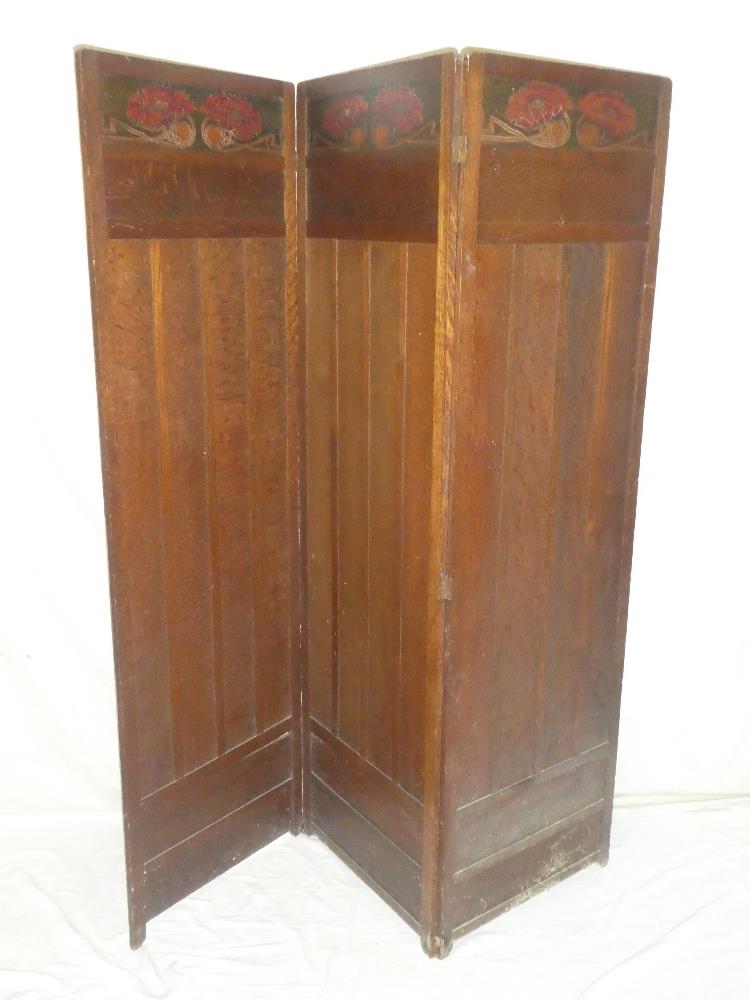 A 1920's/30's Arts and Crafts-style oak three-fold dressing screen with coloured floral decorated