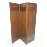 A 1920's/30's Arts and Crafts-style oak three-fold dressing screen with coloured floral decorated