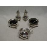 A George V silver five piece cruet set comprising a pair of baluster shaped pepperettes,