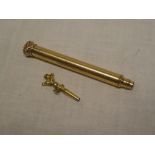 A rolled gold propelling pencil by W Hicks of New York and an unusual miniature pocket watch key