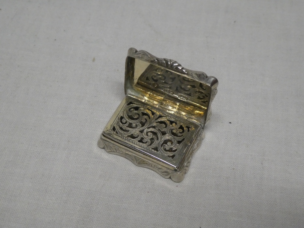 A Victorian silver rectangular vinaigrette with hinged inner pierced cover and engraved scroll - Image 2 of 2