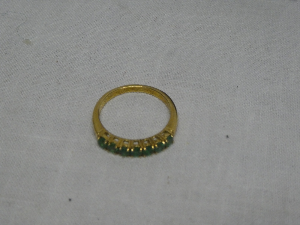 A modern 18ct gold dress ring set emeralds