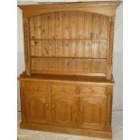 A good quality polished pine kitchen dresser with three drawers in the frieze and cupboard enclosed