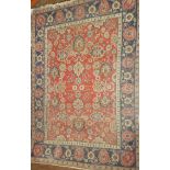 An old Eastern hand-knotted wool rug with floral decoration on red and blue ground 85" x 57"