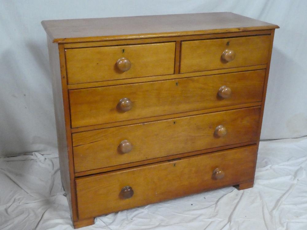 An old polished pine chest of two short and three long drawers with turned handles on bracket feet