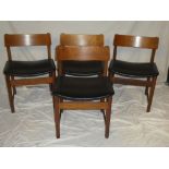 A set of four 1960's/1970's teak dining chairs with vinyl upholstered seats and curved backs