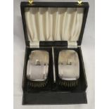 A pair of silver-backed clothes brushes together with matching comb,