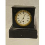 A small late Victorian mantel clock with circular enamelled dial in polished black slate angular