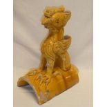 An unusual Chinese yellow glazed ridge tile in the form of a mythic dragon,
