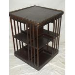 An Edwardian mahogany square revolving bookcase on standard supports
