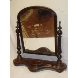 A large Victorian mahogany arched toilet mirror with spiral supports and serpentine-fronted base