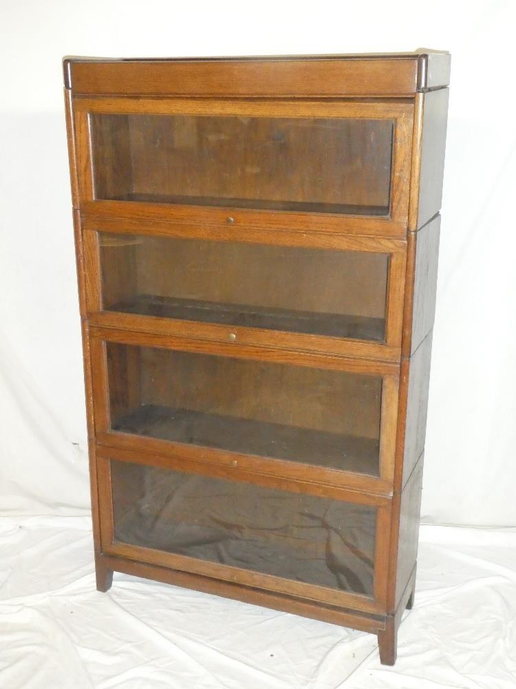 A Globe-Wernicke-style oak four tier stacking bookcase with folding glazed fronts