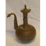 A Middle Eastern copper coffee pot with engraved decoration and hinged lid,
