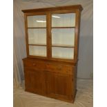 A polished pine kitchen dresser with two drawers in the frieze and cupboard enclosed by two
