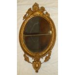 A 19th Century bevelled oval wall mirror in ornate gilt relief decorated frame,