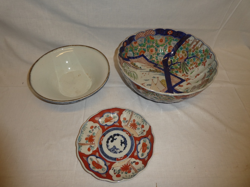 A Japanese Imari pottery circular bowl with painted foliage and landscape decoration and two other