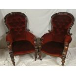 A pair of Victorian mahogany ladies and gents easy chairs upholstered in red buttoned fabric on