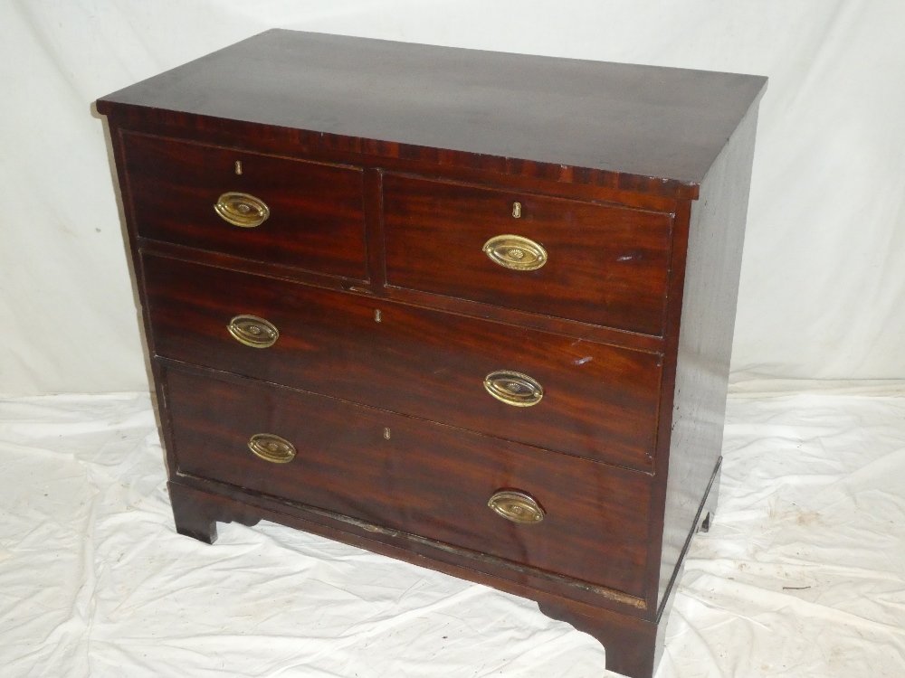 A small 19th Century mahogany chest of two short and two long drawers with brass ring handles on