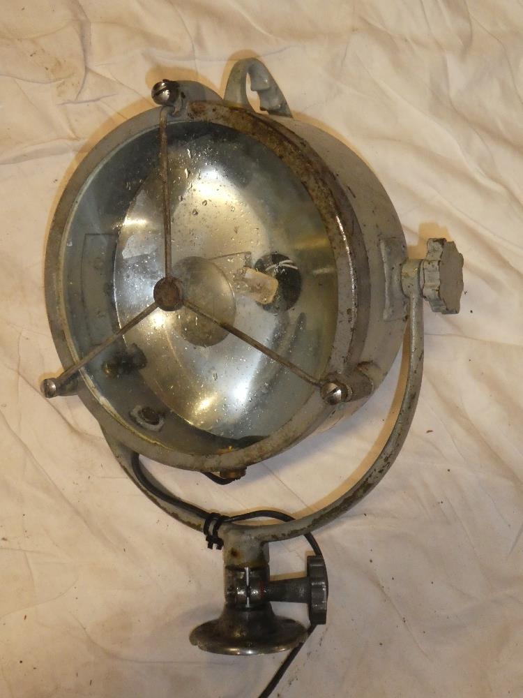 An old painted metal nautical-style search light with circular lens,