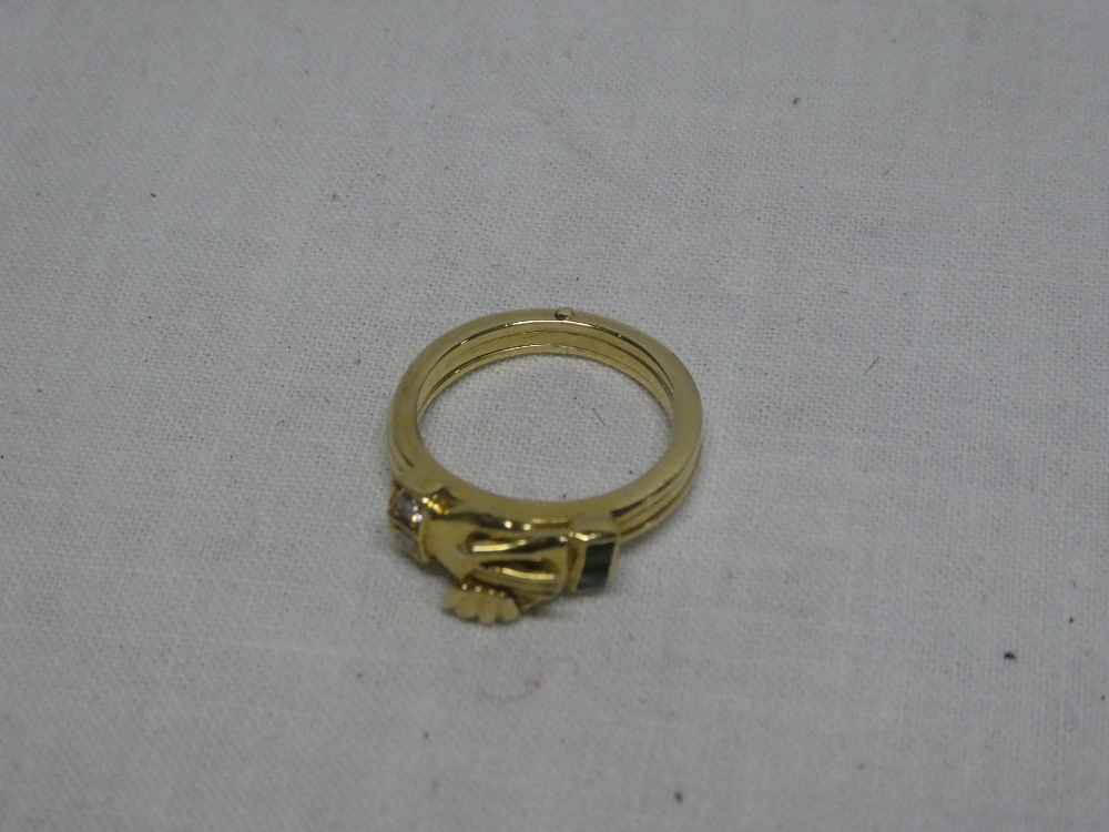 An 18ct gold three-part dress ring with attached clasped hands emblem flanked by two diamonds and