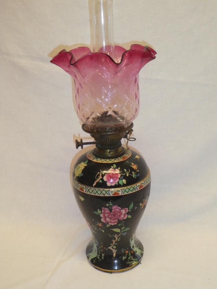 An Edwardian pottery tapered oil lamp with separate reservoir and brass mounts supporting a