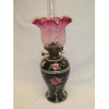 An Edwardian pottery tapered oil lamp with separate reservoir and brass mounts supporting a