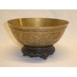 A 20th Century Chinese brass circular bowl with engraved decoration on wooden stand