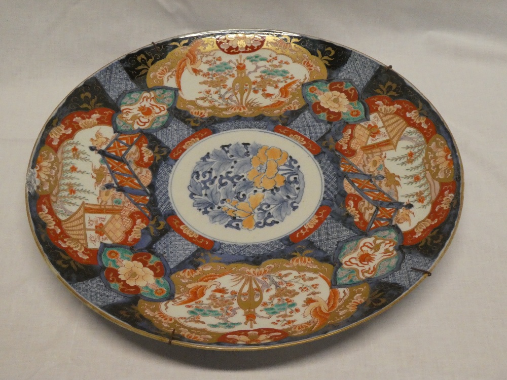 A 19th Century Japanese pottery circular charger with panels of flowers and emblems,