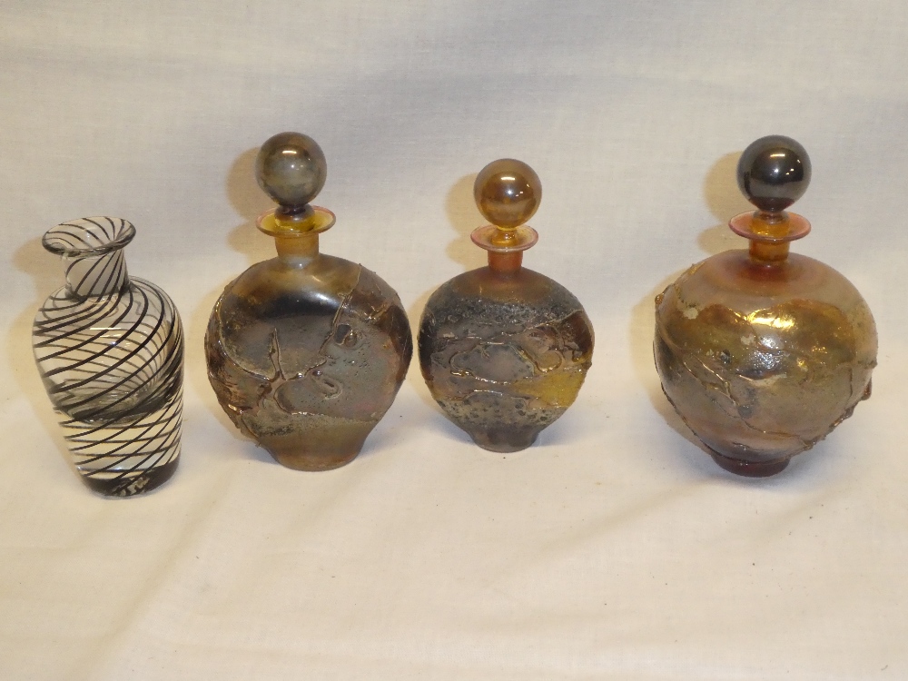 Three various Studio glass scent bottles and stoppers with raised decoration,