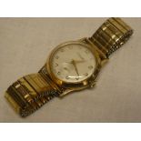 A gentlemans 9ct gold wristwatch by Thomas Russell and Son with elasticated strap