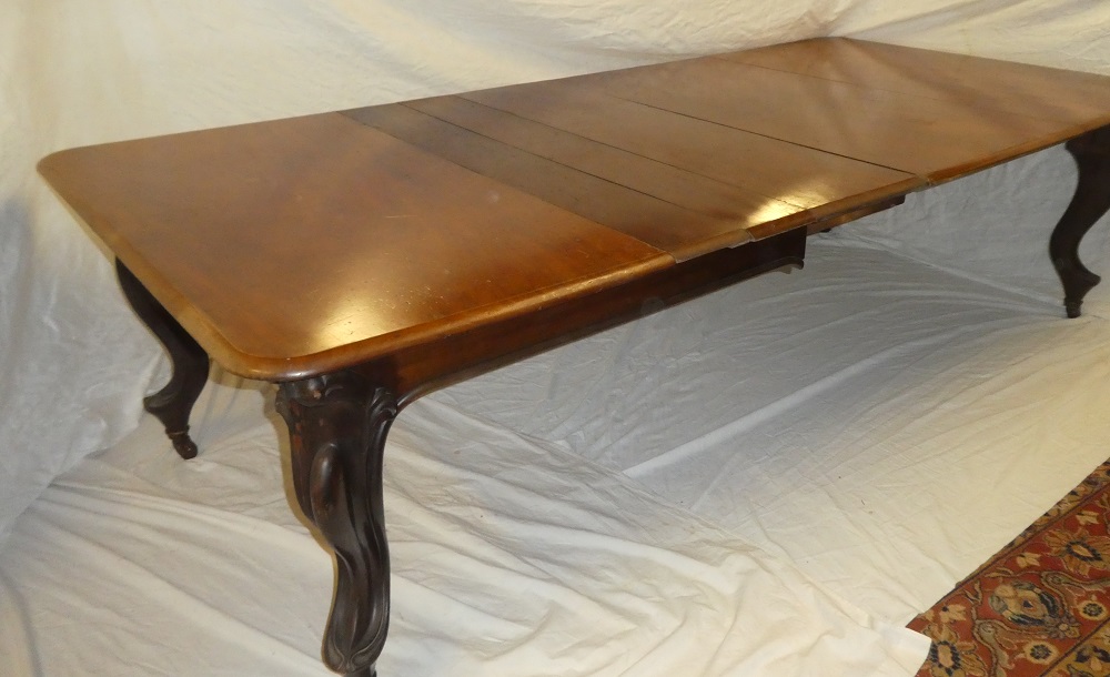 A mid Victorian figured mahogany extending dining table with three additional centre leaves on
