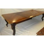 A mid Victorian figured mahogany extending dining table with three additional centre leaves on