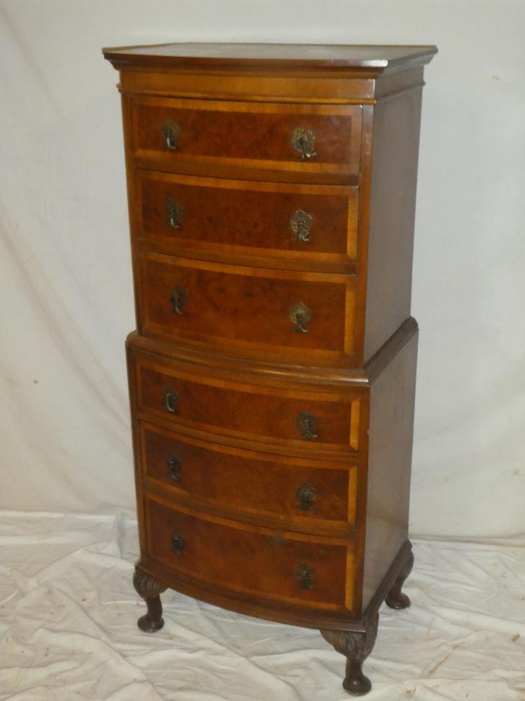 A reproduction mahogany and walnut small-size chest on chest with six curved drawers on cabriole