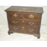 A small George III oak chest of two short and three long drawers with brass ring handles on bracket