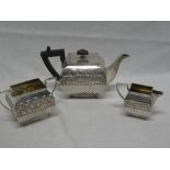 A George V silver rectangular tea-for-two set comprising rectangular teapot with raised floral