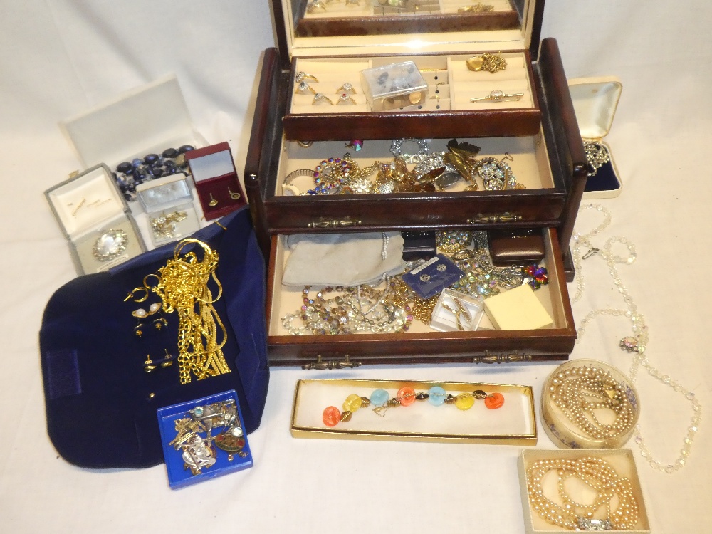 A jewellery box containing a quantity of costume jewellery including necklaces, brooches, earrings,