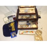 A jewellery box containing a quantity of costume jewellery including necklaces, brooches, earrings,