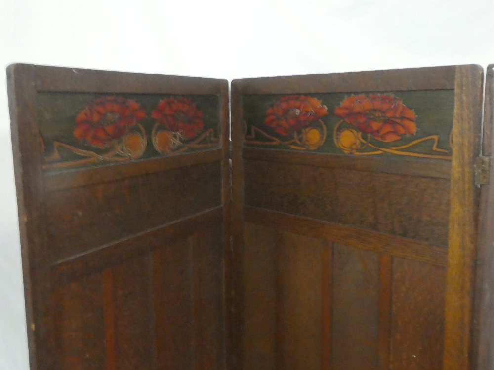 A 1920's/30's Arts and Crafts-style oak three-fold dressing screen with coloured floral decorated - Image 2 of 2